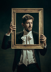 Image showing Young man as Dorian Gray on dark background. Retro style, comparison of eras concept.