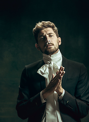 Image showing Young man as Dorian Gray on dark background. Retro style, comparison of eras concept.