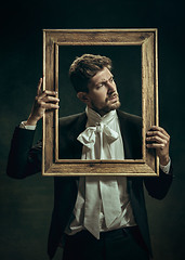 Image showing Young man as Dorian Gray on dark background. Retro style, comparison of eras concept.