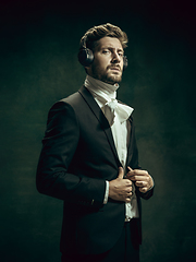 Image showing Young man as Dorian Gray on dark background. Retro style, comparison of eras concept.