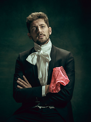 Image showing Young man as Dorian Gray on dark background. Retro style, comparison of eras concept.