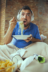 Image showing Lazy man living the whole life in his bed surrounded with messy