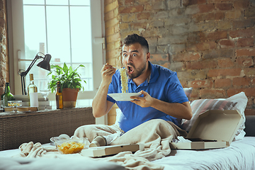 Image showing Lazy man living the whole life in his bed surrounded with messy