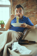 Image showing Lazy man living the whole life in his bed surrounded with messy