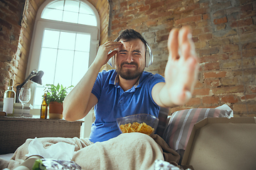 Image showing Lazy man living the whole life in his bed surrounded with messy