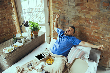 Image showing Lazy man living the whole life in his bed surrounded with messy