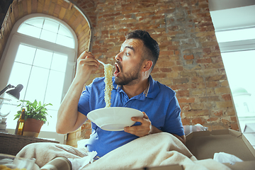 Image showing Lazy man living the whole life in his bed surrounded with messy