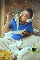 Image showing Lazy man living the whole life in his bed surrounded with messy