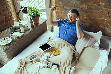 Image showing Lazy man living the whole life in his bed surrounded with messy