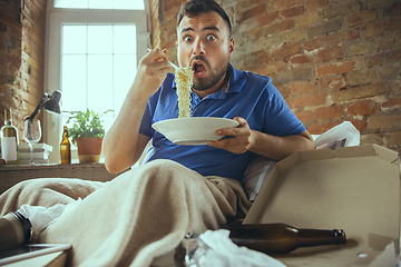 Image showing Lazy man living the whole life in his bed surrounded with messy