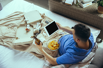 Image showing Lazy man living the whole life in his bed surrounded with messy