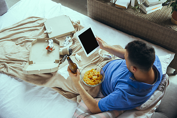 Image showing Lazy man living the whole life in his bed surrounded with messy