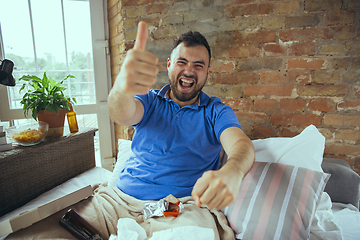 Image showing Lazy man living the whole life in his bed surrounded with messy