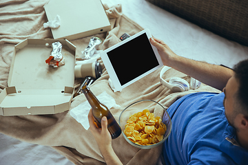 Image showing Lazy man living the whole life in his bed surrounded with messy