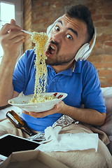 Image showing Lazy man living the whole life in his bed surrounded with messy