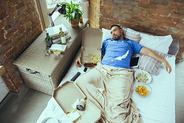 Image showing Lazy man living the whole life in his bed surrounded with messy