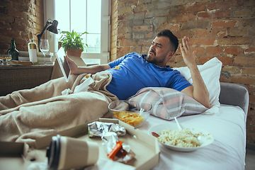 Image showing Lazy man living the whole life in his bed surrounded with messy