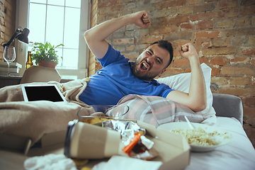 Image showing Lazy man living the whole life in his bed surrounded with messy