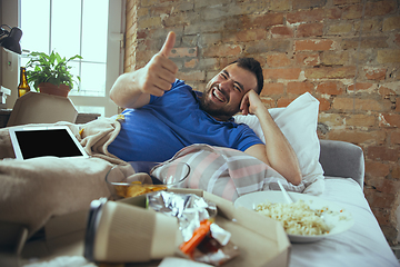 Image showing Lazy man living the whole life in his bed surrounded with messy