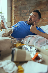 Image showing Lazy man living the whole life in his bed surrounded with messy