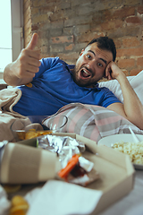 Image showing Lazy man living the whole life in his bed surrounded with messy