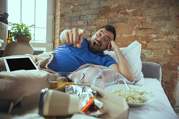 Image showing Lazy man living the whole life in his bed surrounded with messy