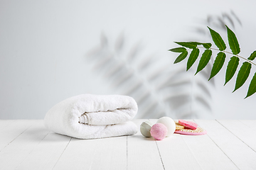 Image showing Beautiful spa composition on massage table in wellness center, copyspace. Leaves\' shadows on the wall