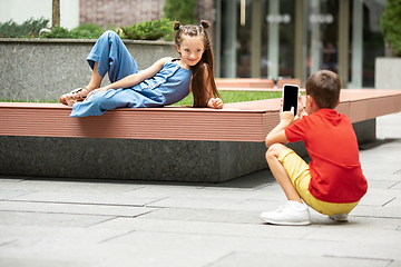 Image showing Two smiling kids, boy and girl taking photo together in town, city in summer day