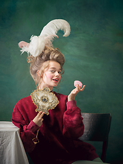 Image showing Young woman as Marie Antoinette on dark background. Retro style, comparison of eras concept.