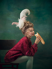 Image showing Young woman as Marie Antoinette on dark background. Retro style, comparison of eras concept.