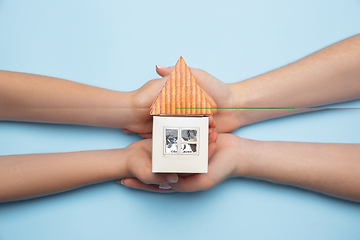 Image showing Real estate and eco concept - close up picture of human hands holding house on blue background