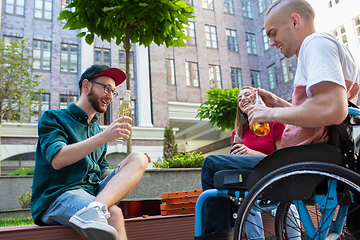 Image showing Group of friends taking a stroll on city\'s street in summer day