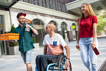 Image showing Group of friends taking a stroll on city\'s street in summer day