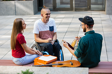 Image showing Group of friends taking a stroll on city\'s street in summer day