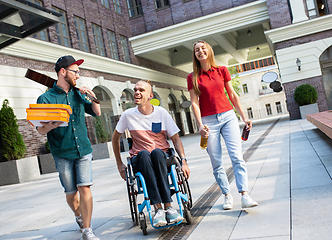 Image showing Group of friends taking a stroll on city\'s street in summer day