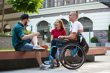 Image showing Group of friends taking a stroll on city\'s street in summer day