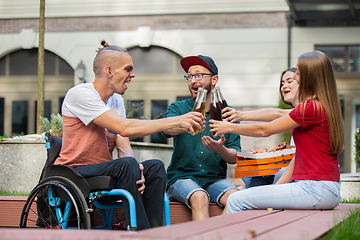 Image showing Group of friends taking a stroll on city\'s street in summer day