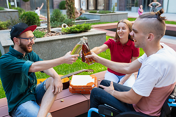 Image showing Group of friends taking a stroll on city\'s street in summer day