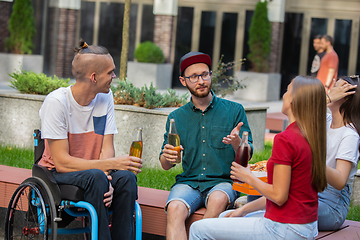 Image showing Group of friends taking a stroll on city\'s street in summer day