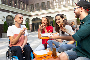 Image showing Group of friends taking a stroll on city\'s street in summer day