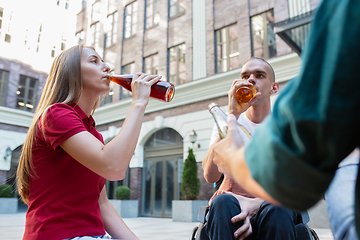 Image showing Group of friends taking a stroll on city\'s street in summer day