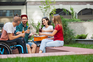 Image showing Group of friends taking a stroll on city\'s street in summer day