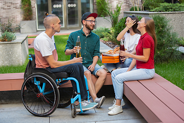 Image showing Group of friends taking a stroll on city\'s street in summer day