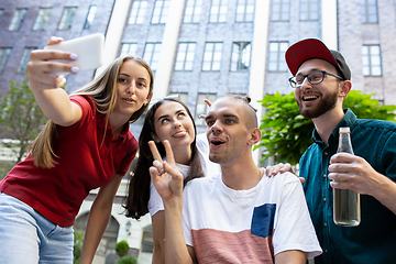 Image showing Group of friends taking a stroll on city\'s street in summer day