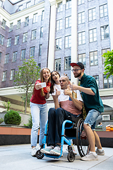 Image showing Group of friends taking a stroll on city\'s street in summer day