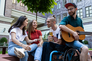 Image showing Group of friends taking a stroll on city\'s street in summer day