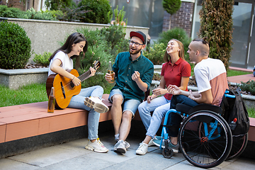 Image showing Group of friends taking a stroll on city\'s street in summer day