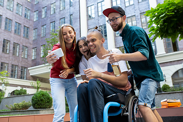 Image showing Group of friends taking a stroll on city\'s street in summer day