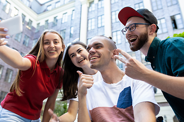 Image showing Group of friends taking a stroll on city\'s street in summer day