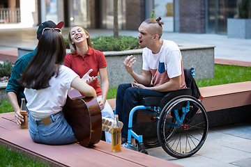 Image showing Group of friends taking a stroll on city\'s street in summer day